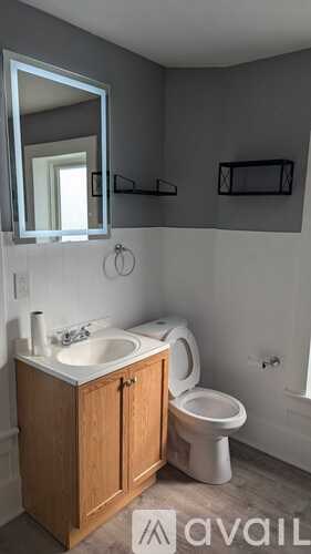 A bathroom with a toilet, sink, and medicine cabinet.