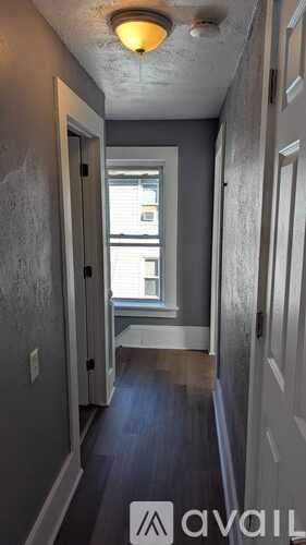 A hallway with a window and a door on the left side.