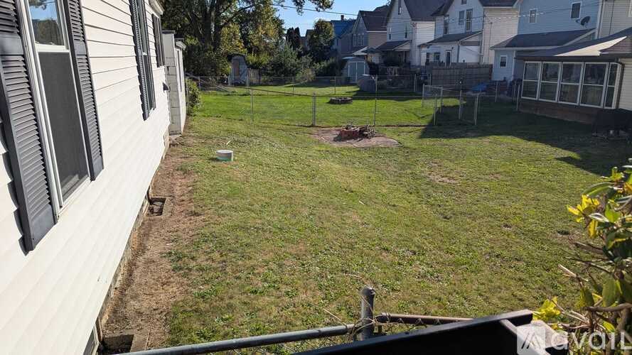 A backyard with a fence and a small patch of dirt.