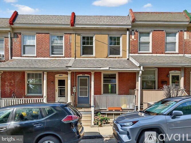 A row of houses with cars parked in front.