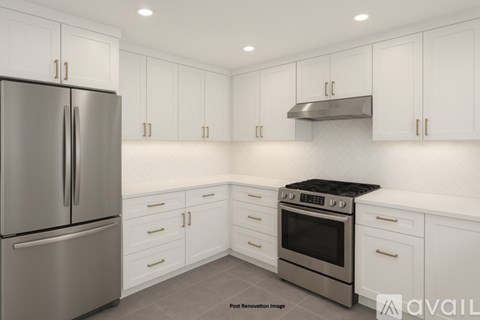 A modern kitchen with white cabinets and stainless steel appliances.