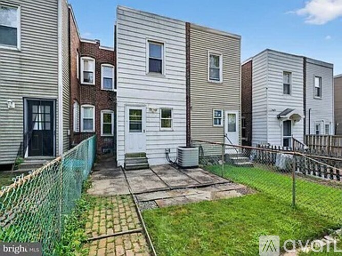 A row of townhouses with a green fence in front.