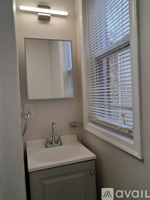 A room with a white door and two windows with wooden frames.