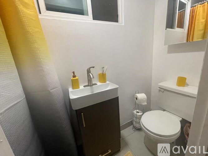 A bathroom with a toilet, sink, and mirror.