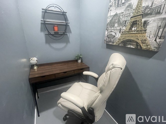 A white chair is in front of a wall with a picture of the Eiffel Tower.
