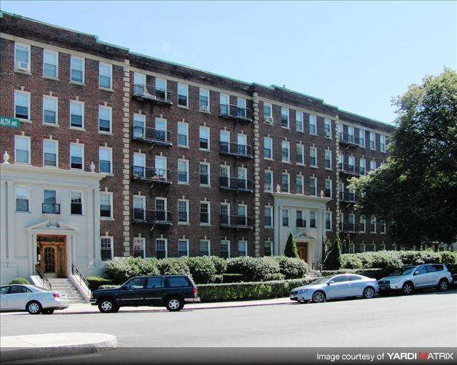 a large brick building with cars parked in front