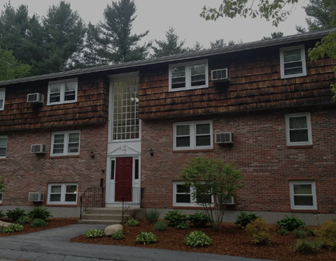 A red brick building with a white door and windows.
