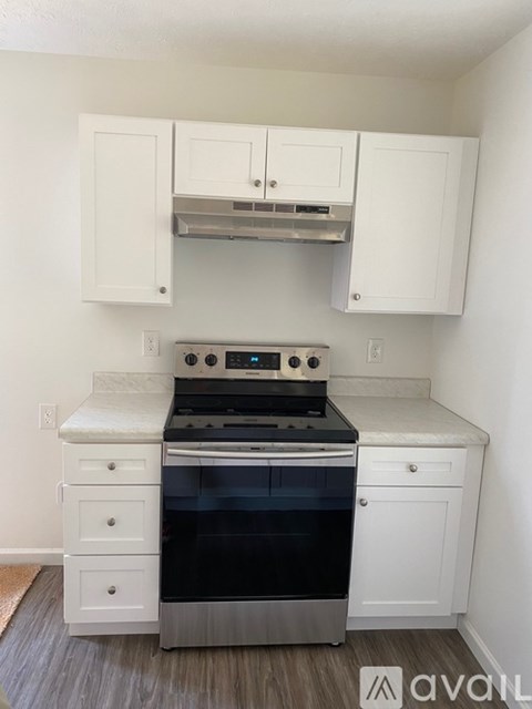 A kitchen with white cabinets and a stainless steel oven.