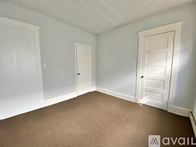 A room with white doors and carpeted floor.