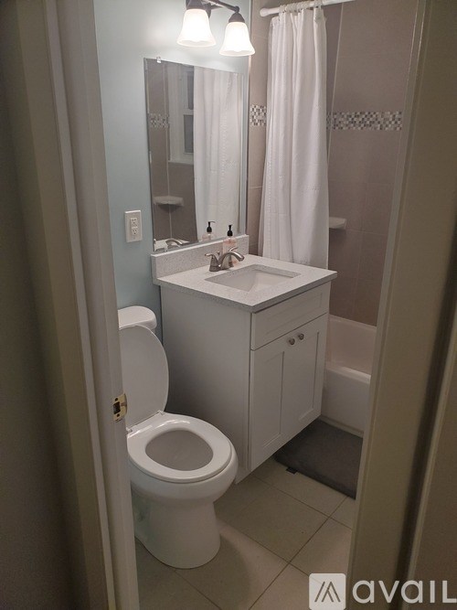 A bathroom with a toilet, sink, and shower.