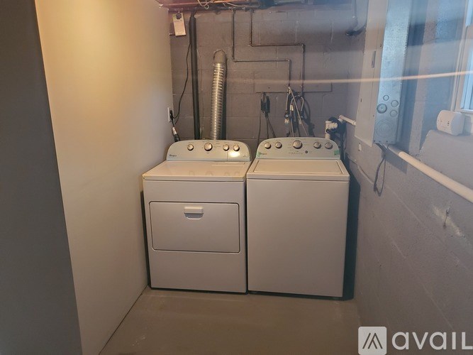 Two white washing machines in a small room.