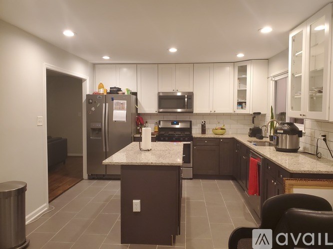 A kitchen with a refrigerator, microwave, and oven.