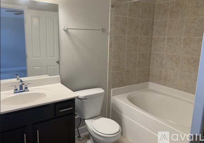 A bathroom with a toilet, sink, and bathtub.