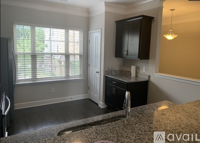A kitchen area with granite countertops and a refrigerator.