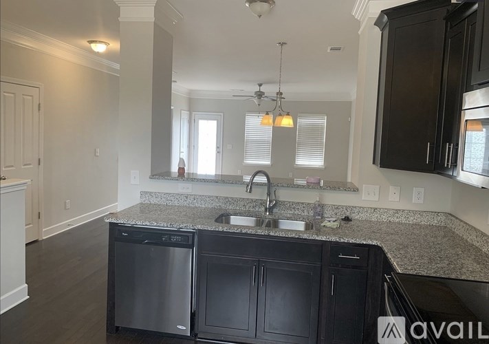 A kitchen with a granite countertop and stainless steel appliances.