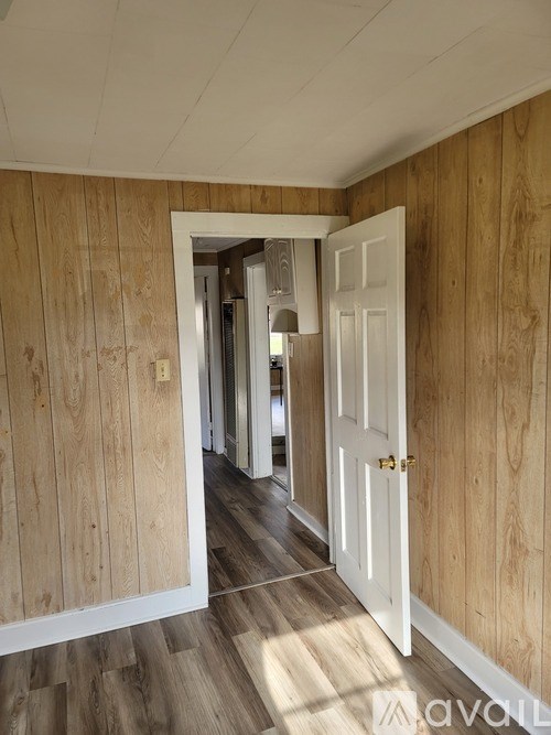 A room with wooden walls and a white door.