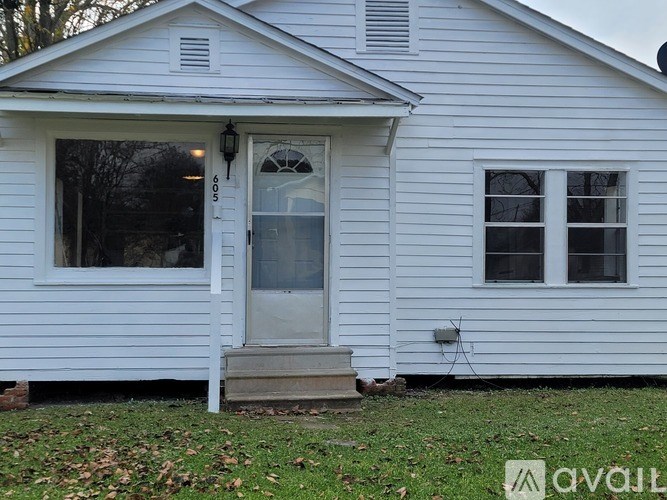 A white house with a grey door and a window.