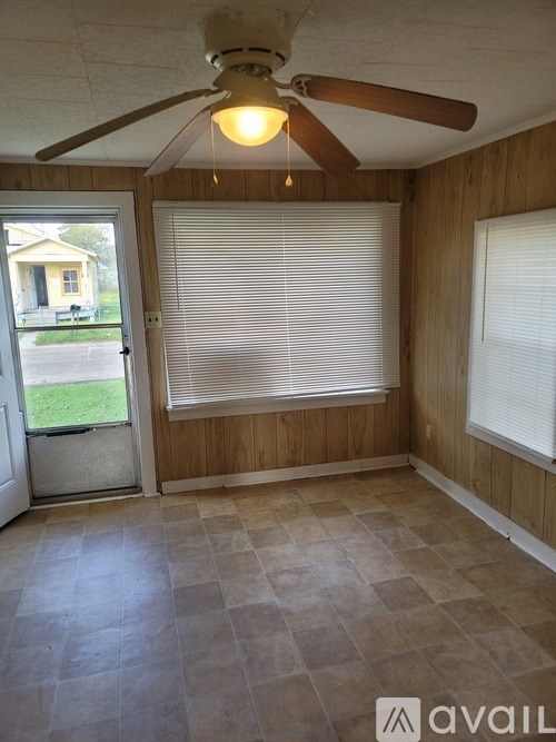 A room with a ceiling fan and a door leading outside.