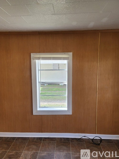 A room with a window and a tiled floor.