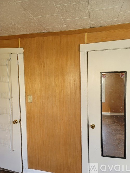 A room with a white door and a wooden door.