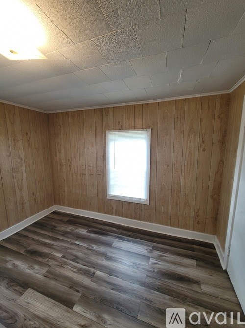 A room with wooden walls and a window.