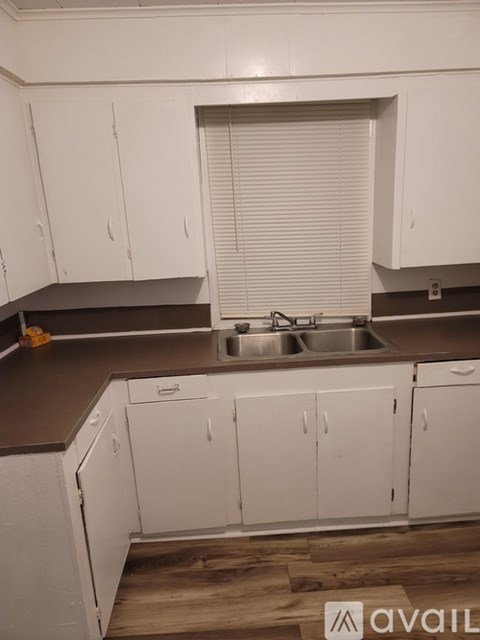 A kitchen with white cabinets and a brown countertop.