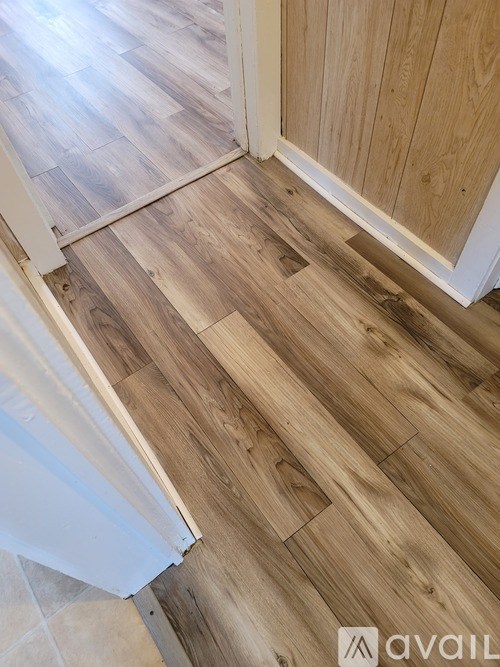 A room with wooden flooring and a white door.
