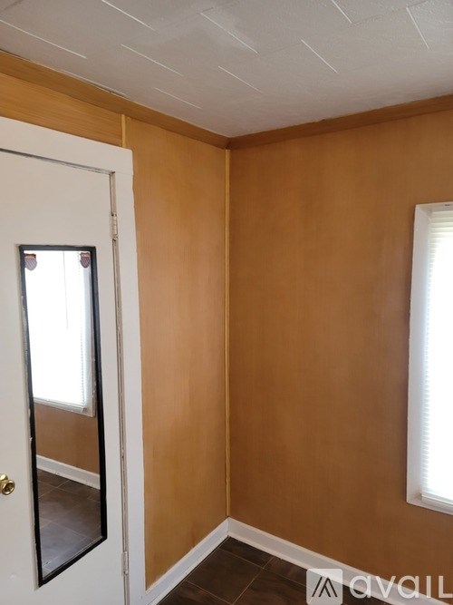 A room with a white door and a window.