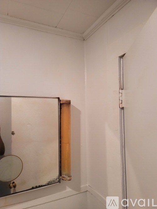 A bathroom with a mirror and a long pipe on the wall.