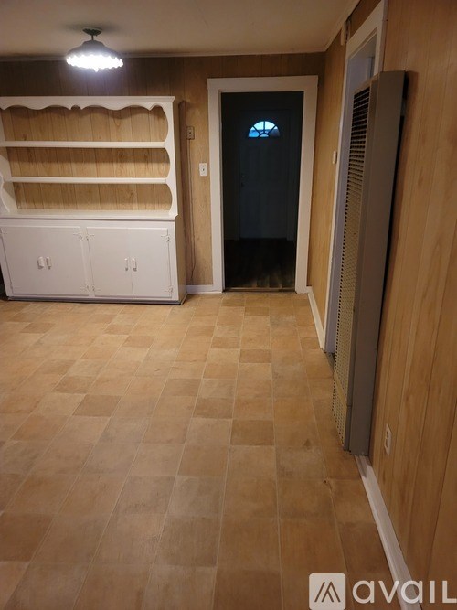 A room with wooden flooring and a white cabinet.