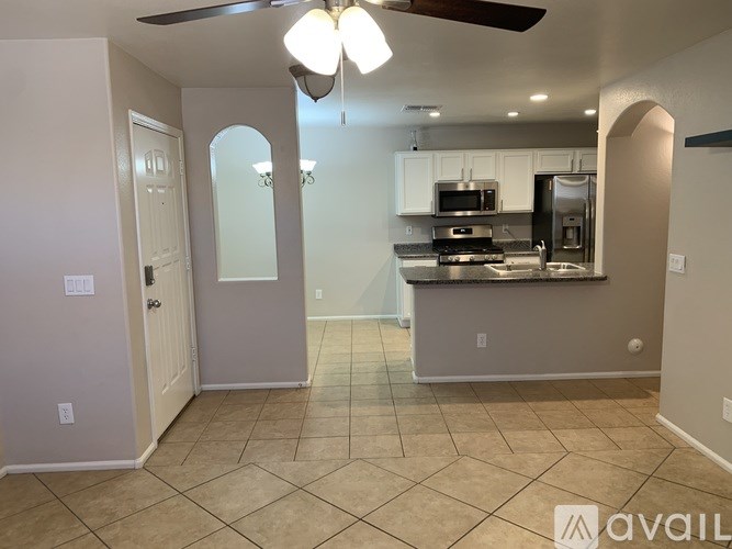 A kitchen with a refrigerator, microwave, and oven.