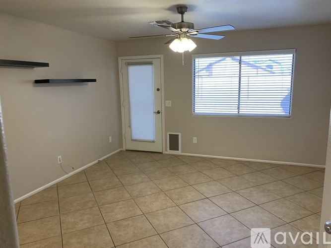 A room with a ceiling fan and a door leading to a hallway.