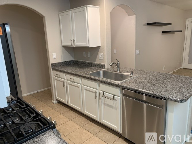 A kitchen with granite countertops and white cabinets.