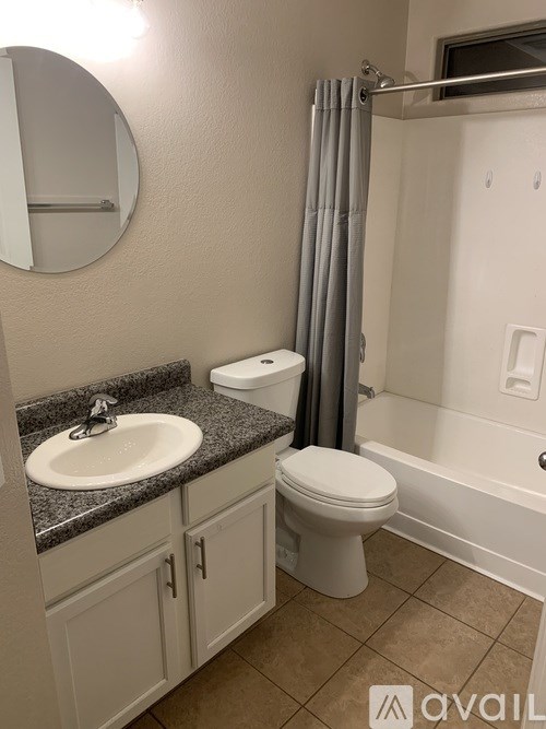 A bathroom with a sink, toilet, and shower.