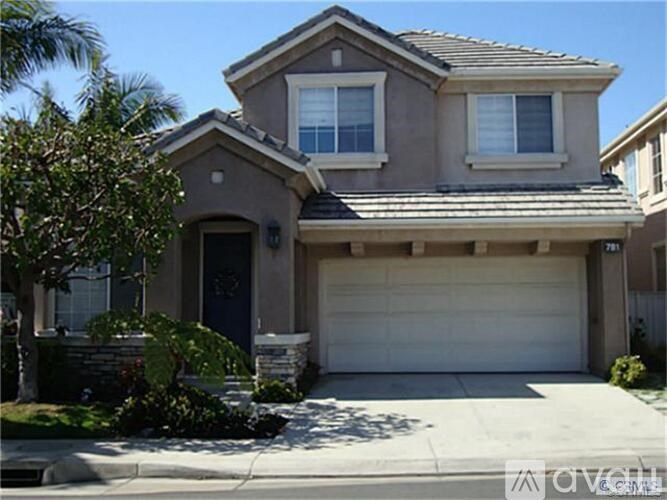 A two-story house with a garage door and a driveway.