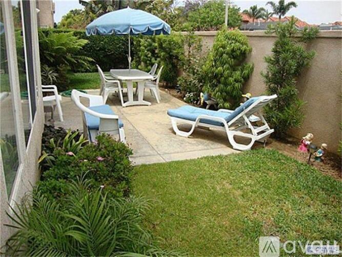 A patio with a table, chairs, and an umbrella.
