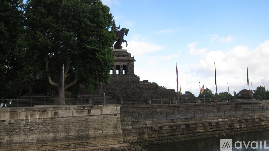 A statue of a person holding a sword stands on a stone structure.