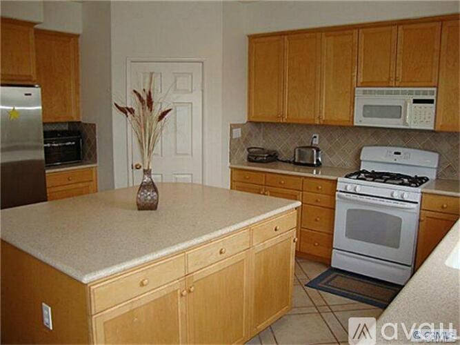 A kitchen with wooden cabinets and a white countertop.