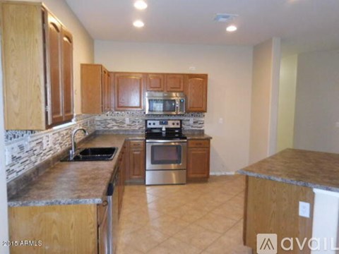 A kitchen with wooden cabinets and a stone backsplash.