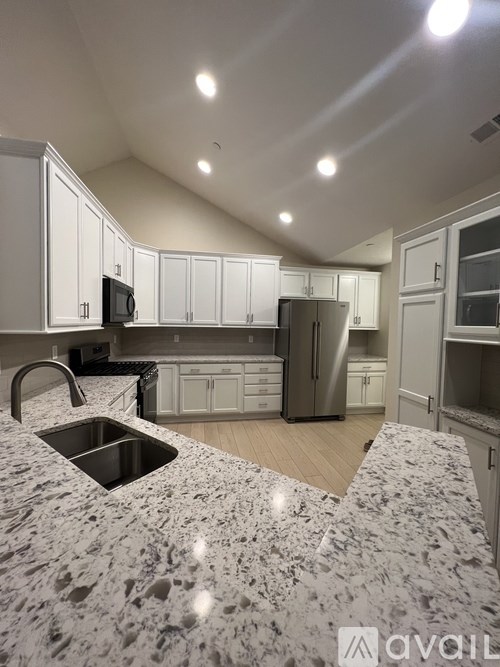 A kitchen with granite countertops and stainless steel appliances.