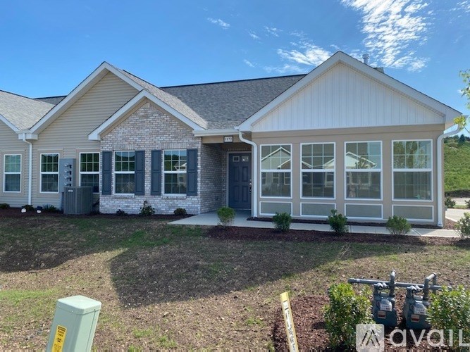 A house with a grey roof and white walls with a blue door.