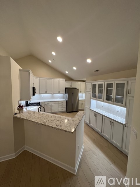 A kitchen with white cabinets and a marble countertop.