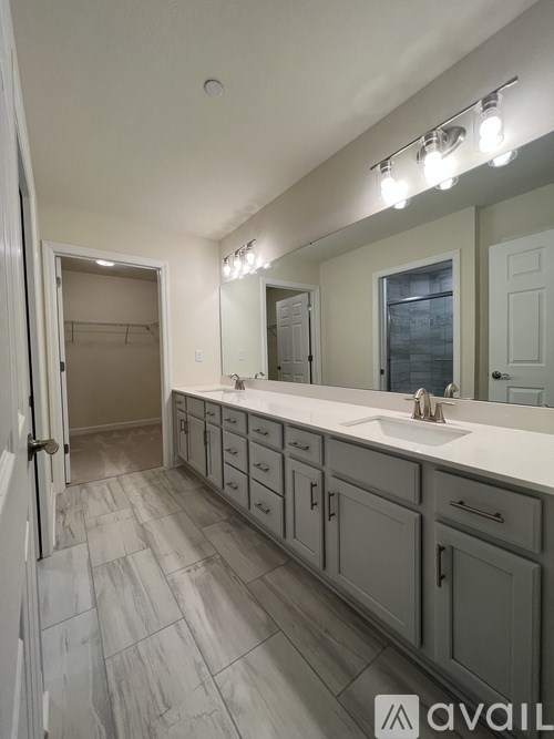 A bathroom with a sink, mirror, and cabinets.