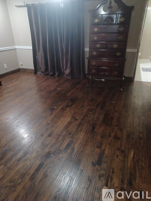 A room with a wooden floor and a wooden wardrobe.