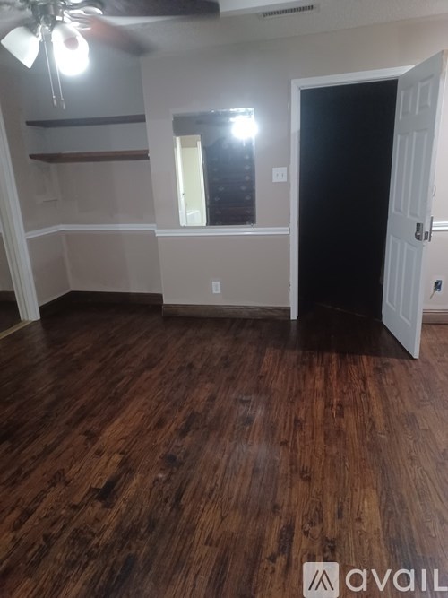 A room with wooden floors and a ceiling fan.