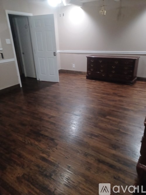 A room with a wooden floor and a white door.