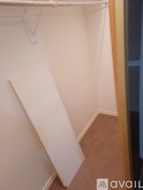 A white closet with a hanger on the wall.