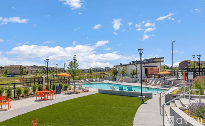 A swimming pool with a grassy area and a walkway.