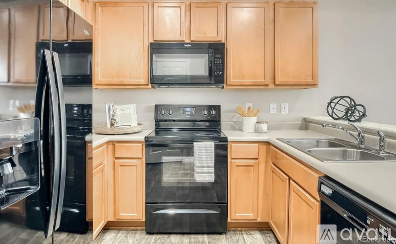 A kitchen with wooden cabinets and black appliances.