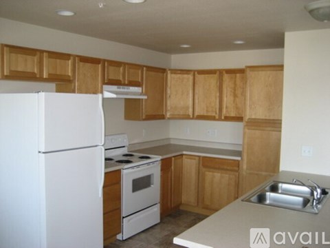 A kitchen with wooden cabinets and white appliances.